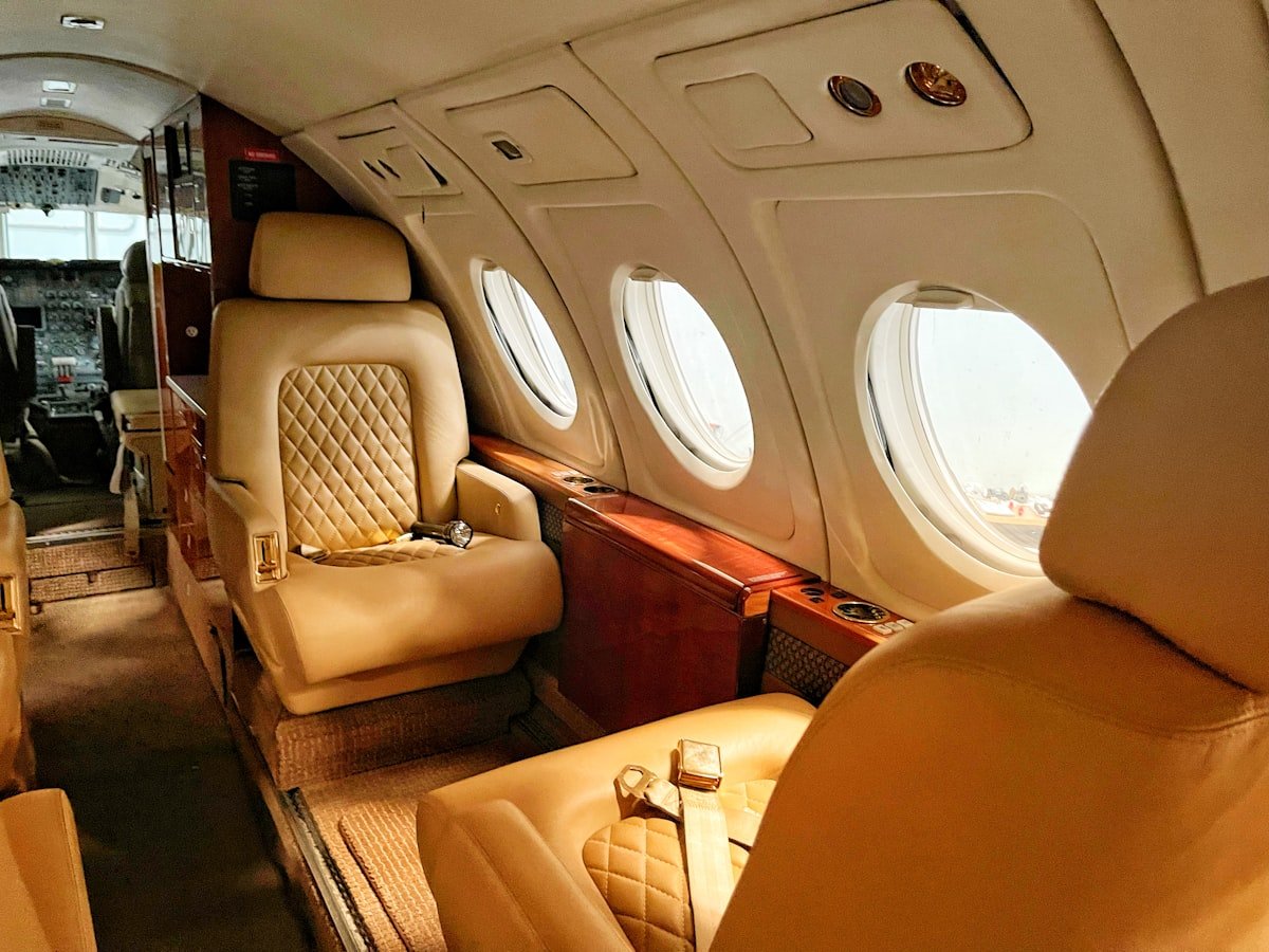 Luxury private jet cabin with cream leather seats and wood-panel detailing