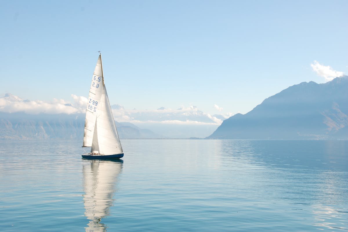 Sailing yacht under full sail between Greek islands with blue Aegean water
